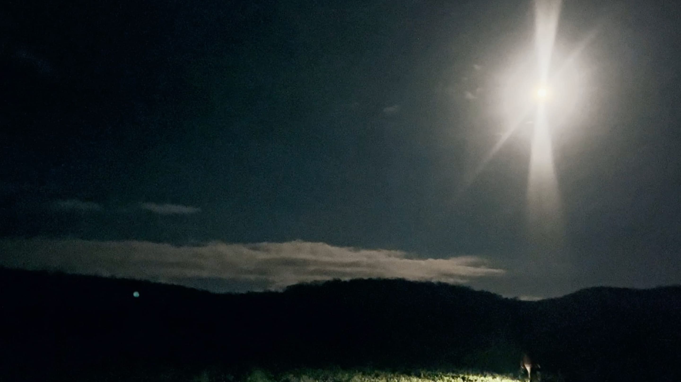 5e photographie d'Anemoia où l'on voit un homme marcher en bas de l'image. La scène se déroule la nuit et la lune et le ciel occupent plus de la moitié de l'écran.